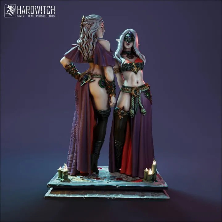 Two dark fantasy female character miniatures on an ornate candlelit display base