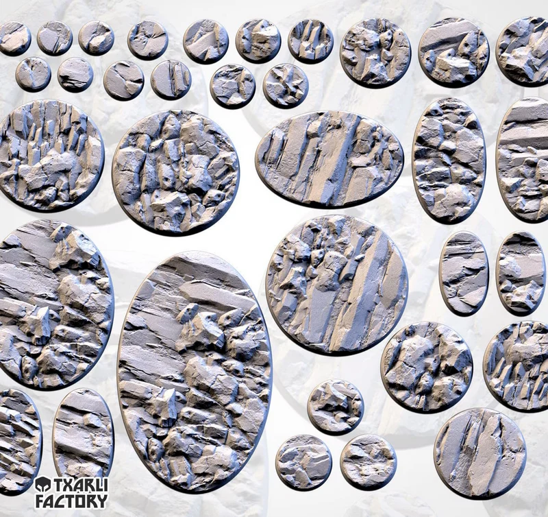 Thirteen round and oval stony tabletop miniature bases with layered rocky surfaces