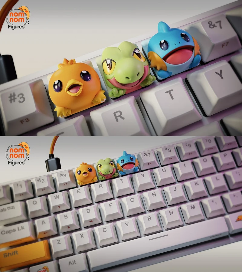 Torchic, Treecko, and Mudkip Hoenn Pokémon figures arranged on a computer keyboard